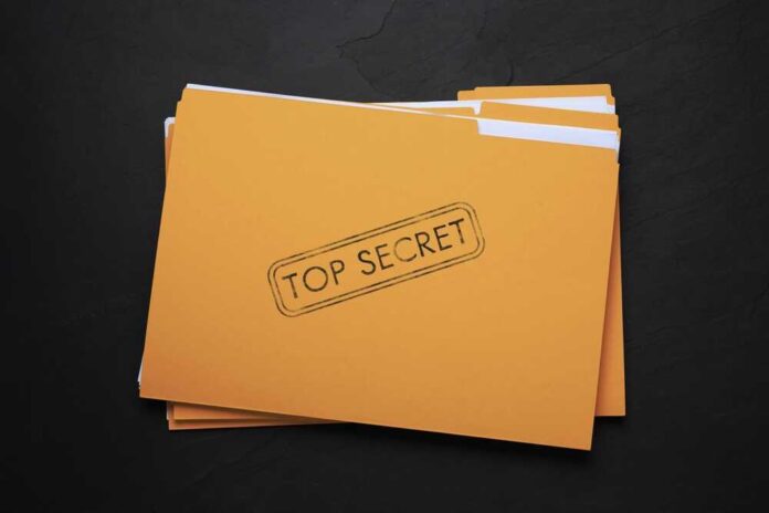 shutterstock_2263579495.jpg featured image Yellow folder labeled Top Secret on black background.