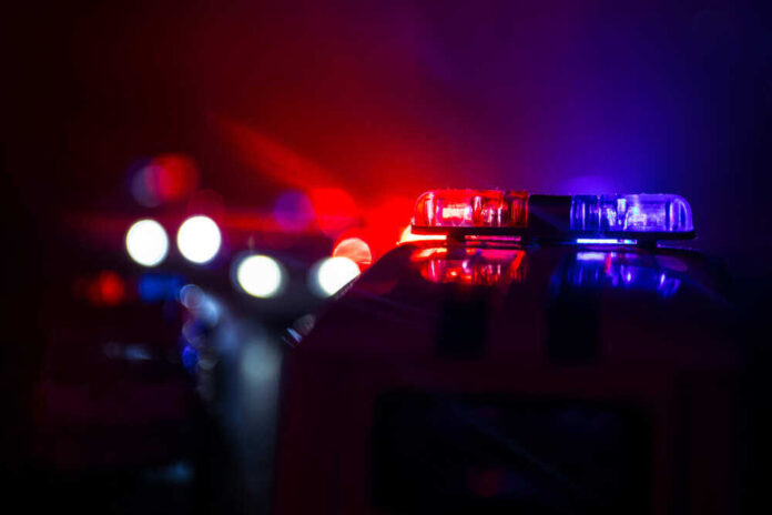 shutterstock_1191163906.jpg featured image Police car lights shining in the dark.