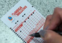 Person filling out lottery numbers on ticket