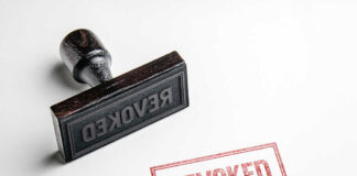 Wooden stamp next to red revoked text stamp