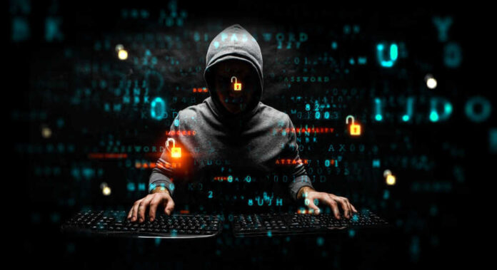shutterstock_1480095632-1.jpg featured image Hacker in dark room with code on screen.