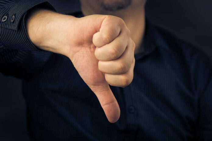 shutterstock_173047226.jpg featured image Hand showing thumbs down gesture, dark background.
