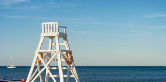 Lifeguard chair on sandy beach near ocean
