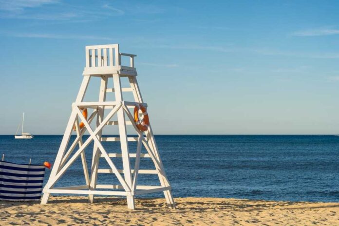shutterstock_2250156417.jpg featured image Lifeguard chair on sandy beach near ocean