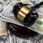 Gavel on pile of hundred dollar bills