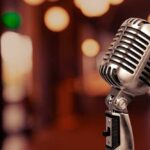 Vintage microphone on a blurred, warm-toned background.