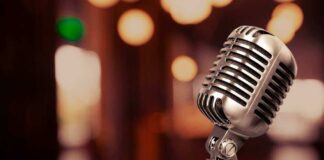 Vintage microphone on a blurred, warm-toned background.