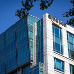 Modern office building with Amazon logo against sky