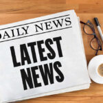 Newspaper with headline latest news on table