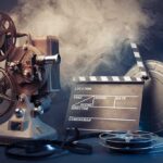 Vintage film projector and clapperboard with reels.