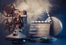 Vintage film projector and clapperboard with reels.