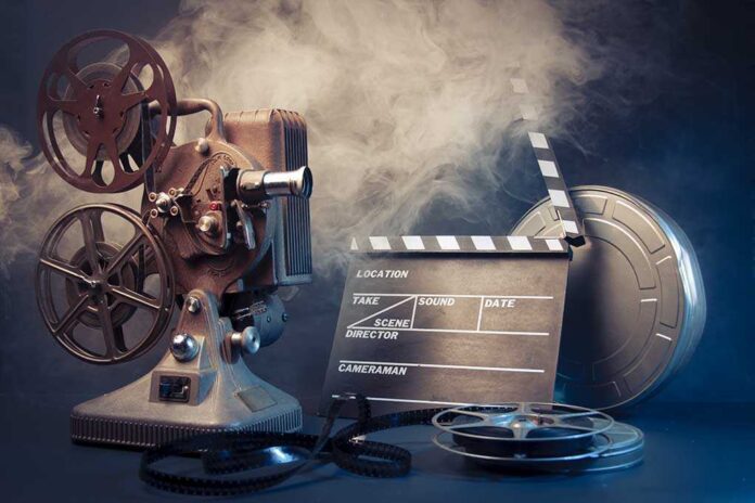 93961807 featured image Vintage film projector and clapperboard with reels.