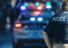 Police officer stands near patrol car