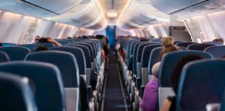 Airplane interior with passengers seated mid-flight.
