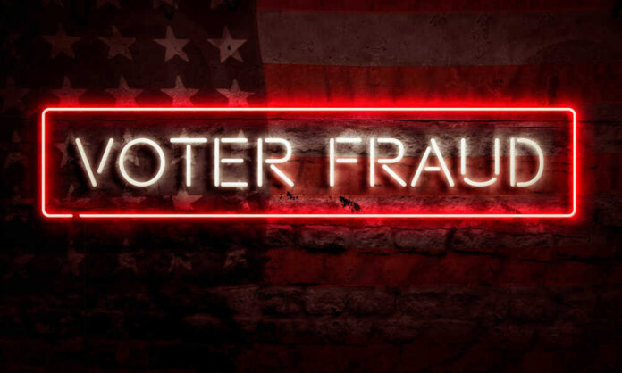Neon sign reading Voter Fraud on American flag background