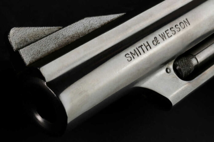 shutterstock_2095014028.jpg Silver Smith and Wesson firearm on black background