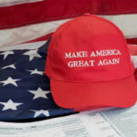 MAGA Base EXPLODES Over Trump’s New China Policy Red Make America Great Again hat on American flag