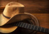 Cowboy hat on guitar next to coiled rope