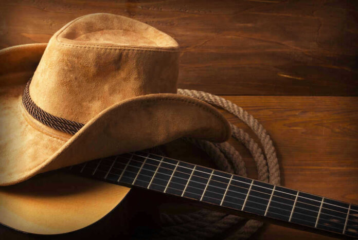 Cowboy hat on guitar next to coiled rope