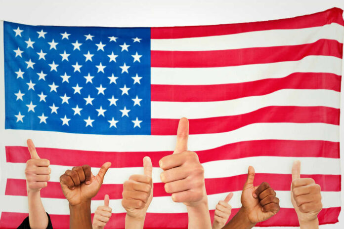 shutterstock_291761663.jpg Thumbs up in front of American flag
