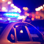 Felon Breaches Airport Security — Mass Shooting Averted?! Police car with flashing blue lights at night