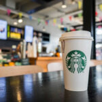 Massive Backlash: Starbucks Under Fire Coffee cup on table in cafe interior