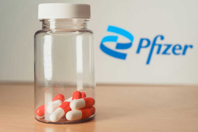 shutterstock_2071944554.jpg Pfizer bottle with red and white capsules