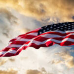 U.S. Forces Nab 7th Tanker American flag waving against a cloudy sky.