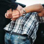 Teenager VANISHES — Adult Male Arrested Person in handcuffs arrested by police officer.