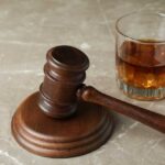 Alcohol Rule Change: No Limits? A wooden gavel next to a glass of whiskey with ice
