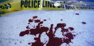 Blood stains on a surface with police caution tape in the background
