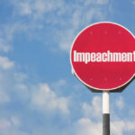 Democrats’ IMPEACHMENT Threat: Trump Under Fire Red sign with the word Impeachment against sky