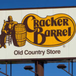 Cracker Barrel Caves to Fan Fury Cracker Barrel Old Country Store sign featuring a man sitting next to a barrel
