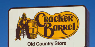 Cracker Barrel Old Country Store sign featuring a man sitting next to a barrel