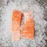 Frozen Salmon DANGER – Families at Risk Now Two pieces of fresh salmon fillet on a bed of ice