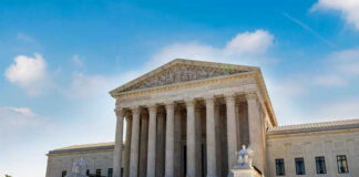 U.S. Supreme Court building exterior under blue sky.