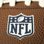 NFL’s Halftime DISASTER — Alternative EXPLODES Instead Close-up of NFL logo on American football.