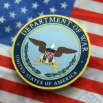 War Department Insider Busted In Fraud Web Seal of the Department of War on an American flag background