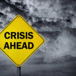 National Humiliation Looms as Sewage Crisis Spirals A yellow warning sign that reads 'CRISIS AHEAD' against a stormy sky