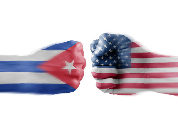 Two fists painted with Cuban and American flags.