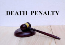 A wooden gavel resting on a block with the words 'DEATH PENALTY' in bold above it