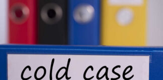 Blue binder labeled 'cold case' with other colored binders in the background