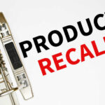 A binder clip holding a sheet of paper with the words 'PRODUCT RECALL' printed in bold letters