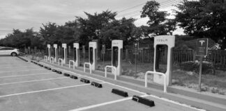 Empty Tesla Supercharger stations in a parking lot.