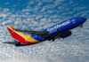 Southwest airplane on the air with blu sky and white clouds.