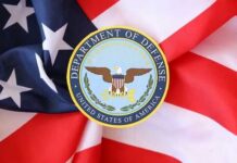 Defense Secretary’s Broker Hunted War Stocks Before Attack? Department of Defense emblem on an American flag background