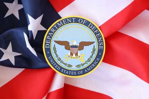 shutterstock_2451551471.jpg Department of Defense emblem on an American flag background