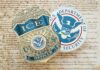 ICE badge and Department of Homeland Security emblem on a textured background