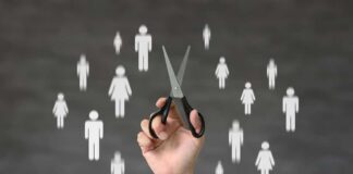 A hand holding scissors with icons of people in the background