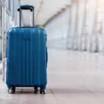 Baggage Bonanza Stuns Rural Town A blue suitcase with wheels positioned in an airport terminal